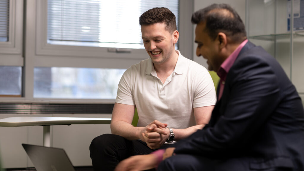 2 members of staff looking at a laptop