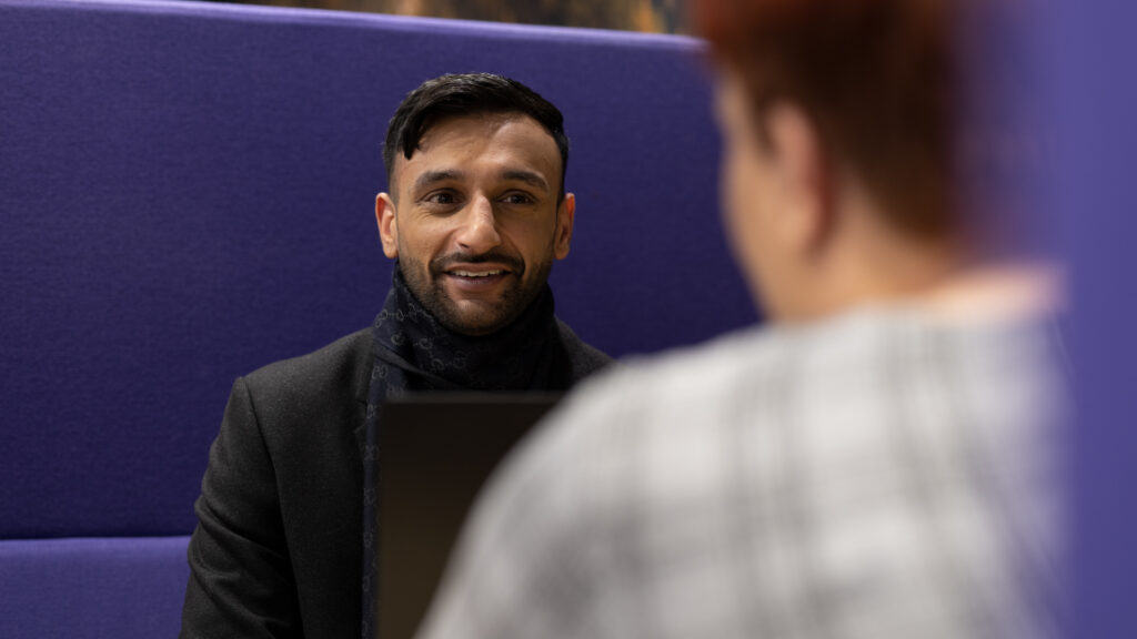 Male member of staff in a purple booth