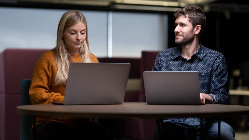 Two members of Home Office staff working at laptops